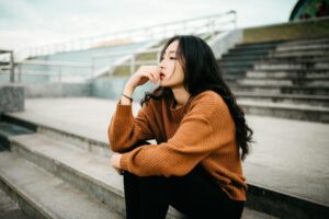 Young woman sitting down and thinking