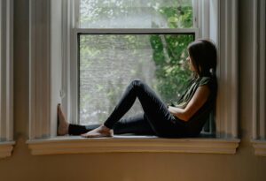 woman looking outside a window